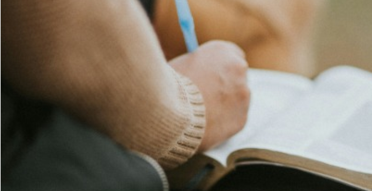 Someone takes notes in their Bible